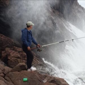 a man fishing on rocks